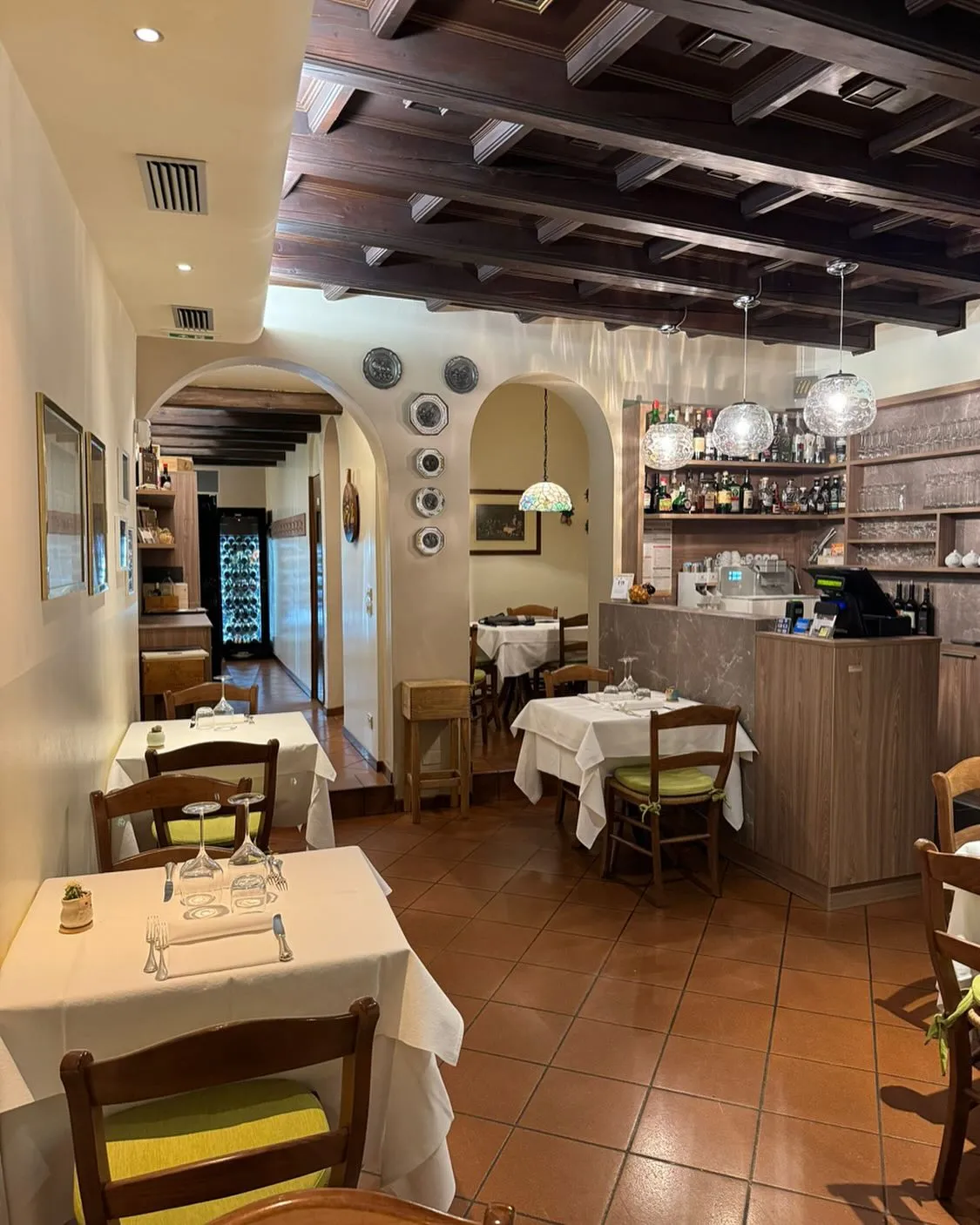 La sala della Trattoria San Pietro: travi a vista e tovaglie bianche